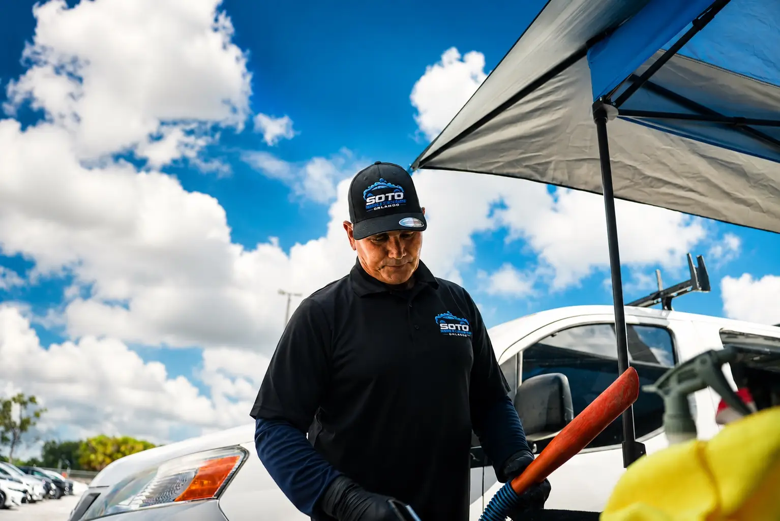 Mobile detailing company in Orlando, FL · detailer working under the mobile canopy