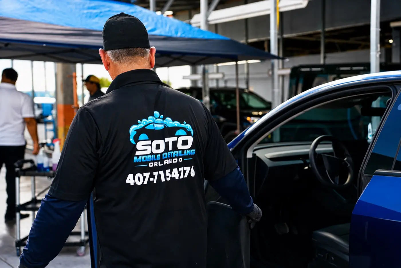 Soto detailer working under the mobile canopy in an Orlando parking lot