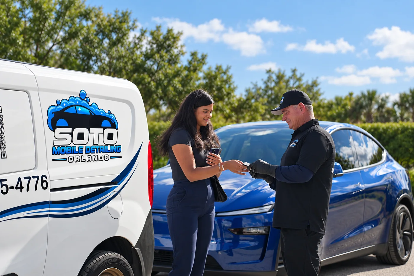 Book mobile detailing in Orlando, FL Book mobile detailing in Orlando, FL · Soto detailer taking the customer's card beside the branded van and her car