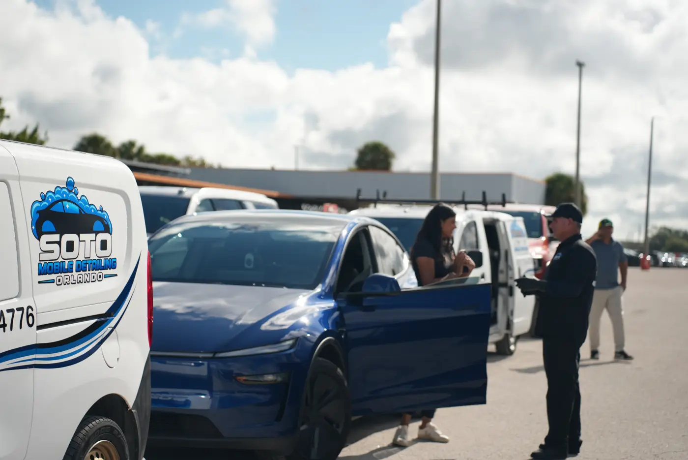 Mobile detailing company in Orlando, FL Ceramic coating in Orlando, FL · Soto detailer talking through the job with a customer beside her blue car