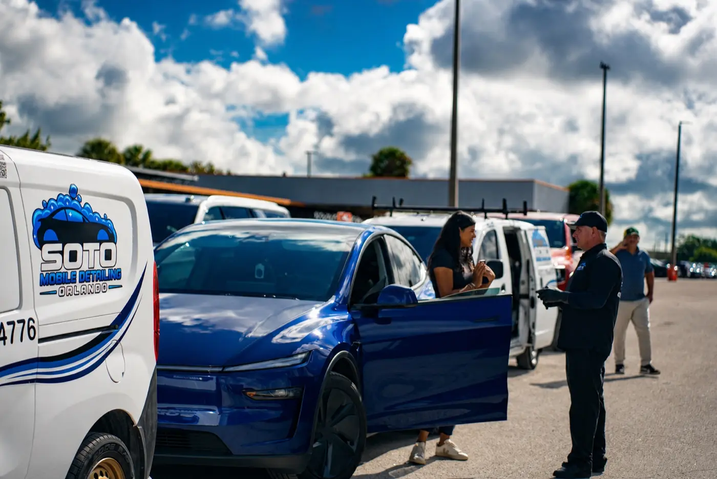 Mobile detailing company in Orlando, FL Ceramic coating in Orlando, FL · Freshly detailed blue car with the door open while the Soto detailer hands it back to the customer