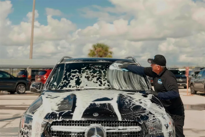 Mobile detailing in Orlando, FL · Soto detailer hand-washing a foamed black Mercedes SUV during a full detail